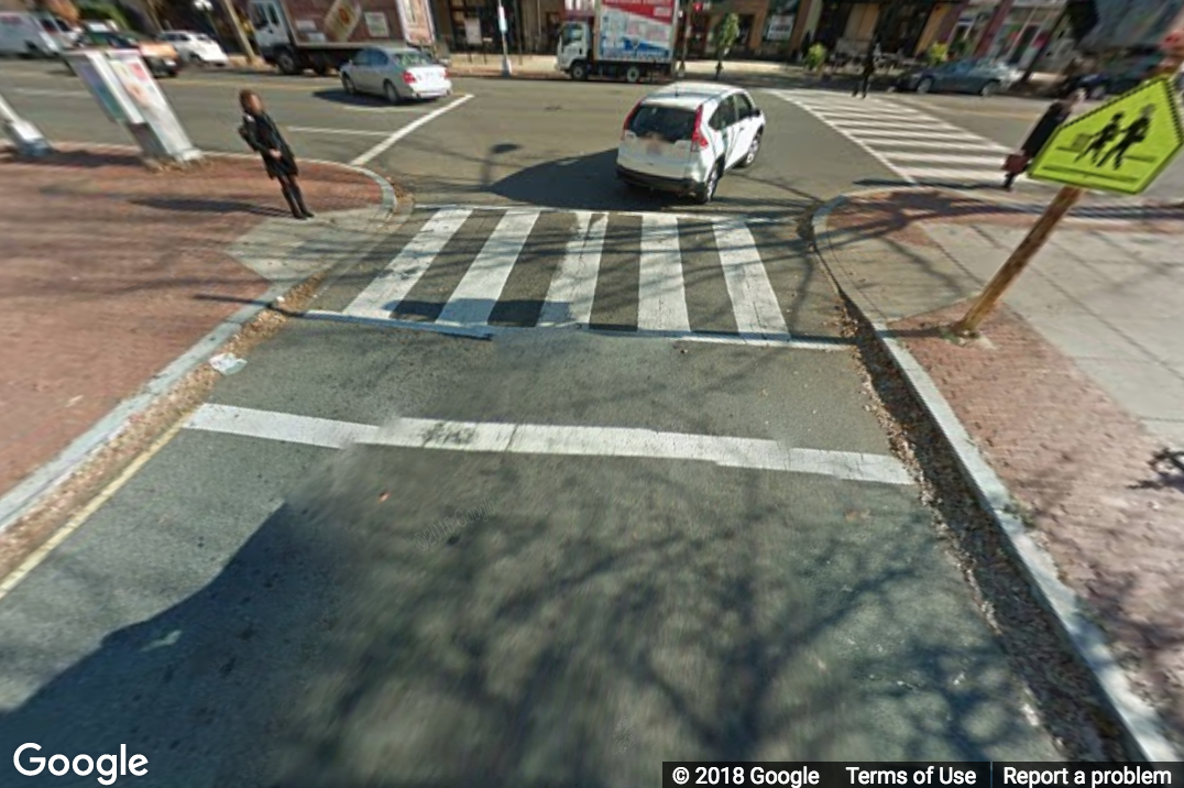 A Street View image of a marked crosswalk connecting two curb ramps